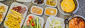 BANNER, LONG FORMAT Turkish breakfast table. Pastries, vegetables, greens, olives, cheeses, fried eggs, spices, jams