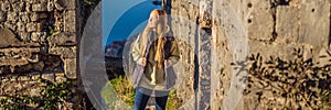 BANNER, LONG FORMAT Young tourist woman enjoying a view of Kotor Bay, Montenegro. Kotor Old Town Ladder of Kotor