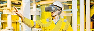 BANNER, LONG FORMAT Young woman in a yellow work uniform, glasses and helmet uses virtual reality glasses in industrial