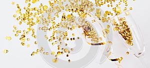 Banner made of glasses with gold confetti tinsel on white background. Flat lay, top view, copy space. Celebrate party