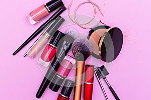 Banner. Make up the essentials. A set of professional makeup brushes and cosmetics on a pink background