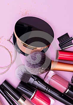 Banner. Make up the essentials. A set of professional makeup brushes and cosmetics on a pink background.