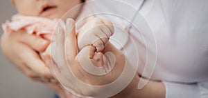 Banner Mother with newborn baby hold hands closeup. Concept help and support adoption