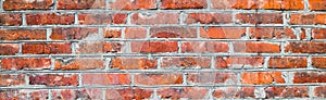 Banner with old shabby and wrecked red brick wall with grey cement mortar as background. Copy space