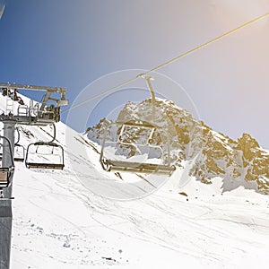 Banner panorama of ski resort, skiers on the ski lift, white snow pine trees at pink sunset or dawn