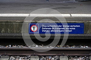 Banner with a pictogram saying it is forbidden to cross the tracks at the railway station in Urdorf, Switzerland.