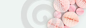 Banner with pink tissue paper balls different sizes on a blue background.