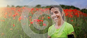 Banner with portrait hispanic woman in colored sportswear on background of poppy field on sun day