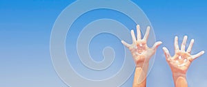 Banner of positive symbol drawing by sunscreen (sun cream, suntan lotion) on two Caucasians open hands o.