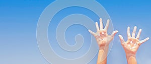 Banner of positive symbol drawing by sunscreen (sun cream, suntan lotion) on two Caucasians open hands o. photo