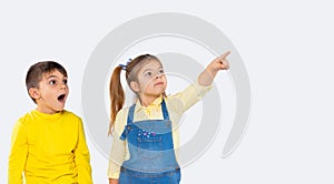 Banner. A preschool girl points with her forefinger to something in the distance, the boy looks and is surprised