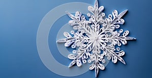 Banner of quilling with white snowflake closeup on blue background top view. Merry Christmas and Happy New Year holiday concept