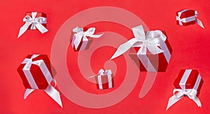 Banner red gift boxs with white satin ribbon bow flying on red background. Minimal concept for christmas holidays, birthday,