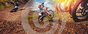 Banner rider on mountain dirtbike enduro participates in motocross, jumps on springboard against background dirt