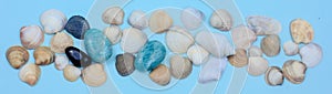 Banner, seashells, white, blue and black stones on a blue background. amazonite and sea pebbles