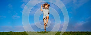 Banner with spring child face. Little boy running and jumping on the grass near a spring green meadow on blue sky. Happy