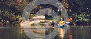 Banner of summer kayaking. Happy young caucasian woman floating in blue kayak at river. Copy space. The concept of World