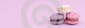 Banner sweet colorful macarons isolated on pink background.
