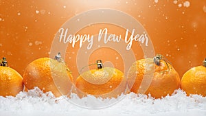 Banner with tangerines in the form of Christmas decorations on the snow, with falling snow. Happy Christmas or Happy New Year,