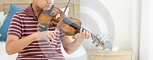 Banner teenage boy, smiling, playing, practicing violin musical instrument with happiness in bedroom at cozy home in leisure time