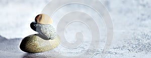 Banner theme of relaxation and meditation. Stones on gray background with space for copying. Balance and equilibrium.