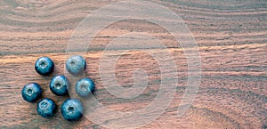 Banner top view of blueberries on wooden background