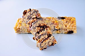 Banner two granola bars lie on top of each other on a blue table view from the side close up