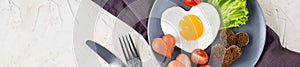 banner of Valentines day breakfast with heart shaped fried eggs served on grey plate