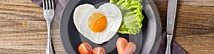 banner of Valentines day breakfast with heart shaped fried eggs served on grey plate