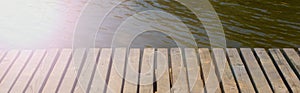 Banner Vintage wooden table on the background of a blurred water background.