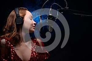 Banner. Vocalist sings in the studio. Practice and school of vocal. Music and teaching. Effective photo with blue and orange smoke