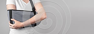 Banner with woman holding painful elbow in sling. Arm injury, overuse, inflammation consequences. Health care concept