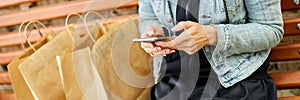 Banner of Woman sitting on the bench in the park withpaper shopping bags after shopping