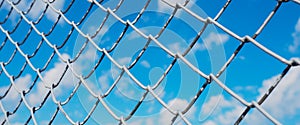 banner wor website, A fence made of wire mesh, netting covered with white on the background of blue sky and sunshine