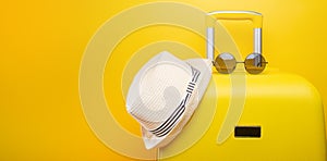 Banner yellow suitcase, with a hat for recreation, the beach and sunglasses. Travel Things Concept Festive Adventure Travel, on