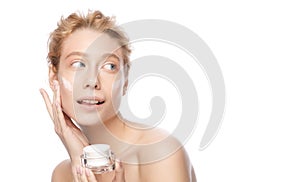 Banner of young beautiful woman with clear skin holding cosmetic jar and applying face cream