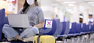 Banner of young woman traveller wearing face maks using laptop computer at airport