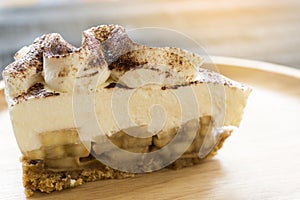 Banoffee pie with chocolate powder on wooden plate photo