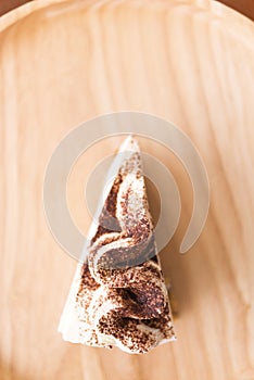 Banoffee pie with chocolate powder on wooden plate soft focus se photo