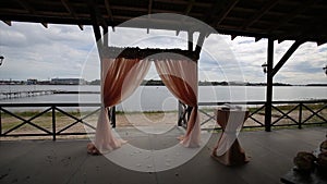 Banquet hall on the shores. Wedding ceremony on the shore. Decorated wedding table on the beach, soft evening light