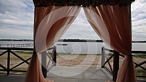 Banquet hall on the shores. Wedding ceremony on the shore. Decorated wedding table on the beach, soft evening light