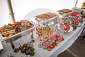 Banquet table with chafing dish heaters. Grilled meat