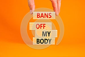 Bans off my body symbol. Concept words Bans off my body on wooden blocks on a beautiful orange table orange background. Women