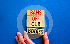 Bans off our bodies symbol. Concept words Bans off our bodies on wooden blocks on beautiful blue table blue background. Women