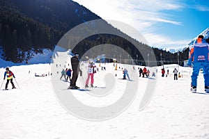 Bansko, Bulgaria, January 27, 2016: Ski resort Bansko, Bulgaria, ski slopes and mountain with pine trees, people walking and skii