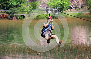 Men enjoying zip-line flying over the forest at Tadom Hill Resort