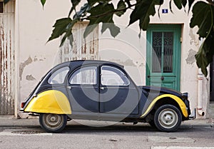 Vintage Citroen 2CV, black and yellow in colour parked on street outside house