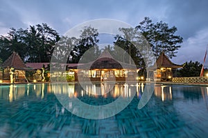 Banyuwangi, Indonesia - Architecture wooden resort bali style with swimming pool and illumination in dusk