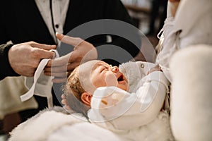 baptism baby. cute little head of a girl under holy water at chr