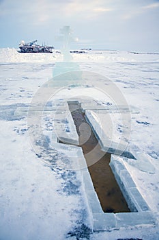 Baptism, bathing in the winter ice hole, beautiful winter landscape with an ice cross on a frozen river